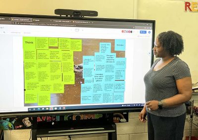 teacher in front of classroom distance learning board